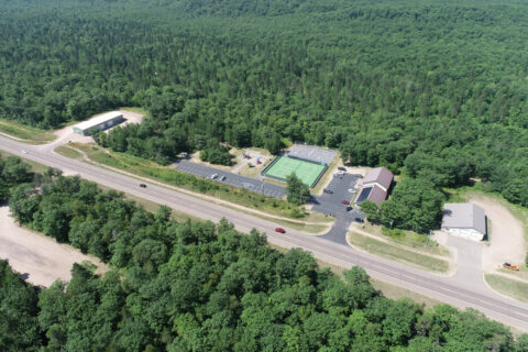 Aerial view of countryside complex with tennis courts.