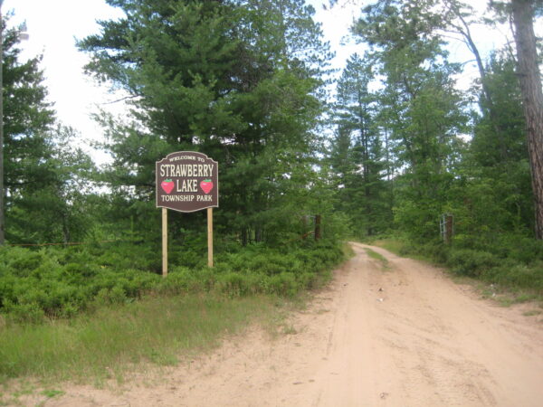 Strawberry Lake Township Park entrance sign and dirt road.